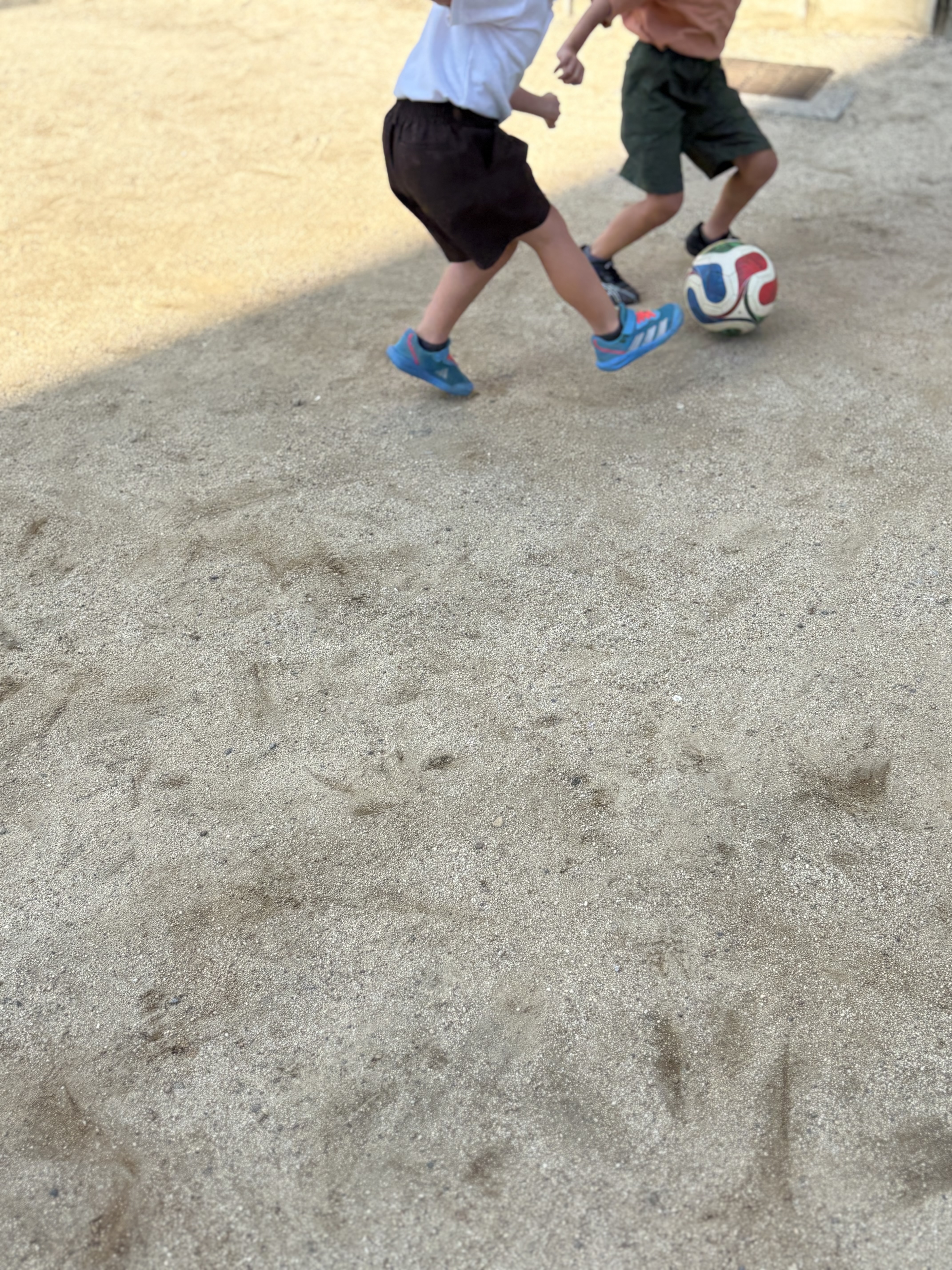 「一歩も引かない激しいボールの奪い合い！縦横無尽のダッシュ！」

子どもたちがこばやんさんのディフェンスに負けじと、体幹をしっかり使ってボールをキープし、全力で駆け抜ける粗大運動の1コマ。