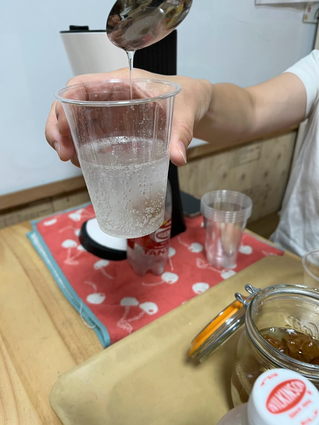 「シュワシュワ〜！シロップに炭酸水を注ぐ魔法の瞬間」
グラスに注いだ梅シロップへ炭酸水を注ぎ、泡が弾ける清涼感たっぷりの手元アプローチ。