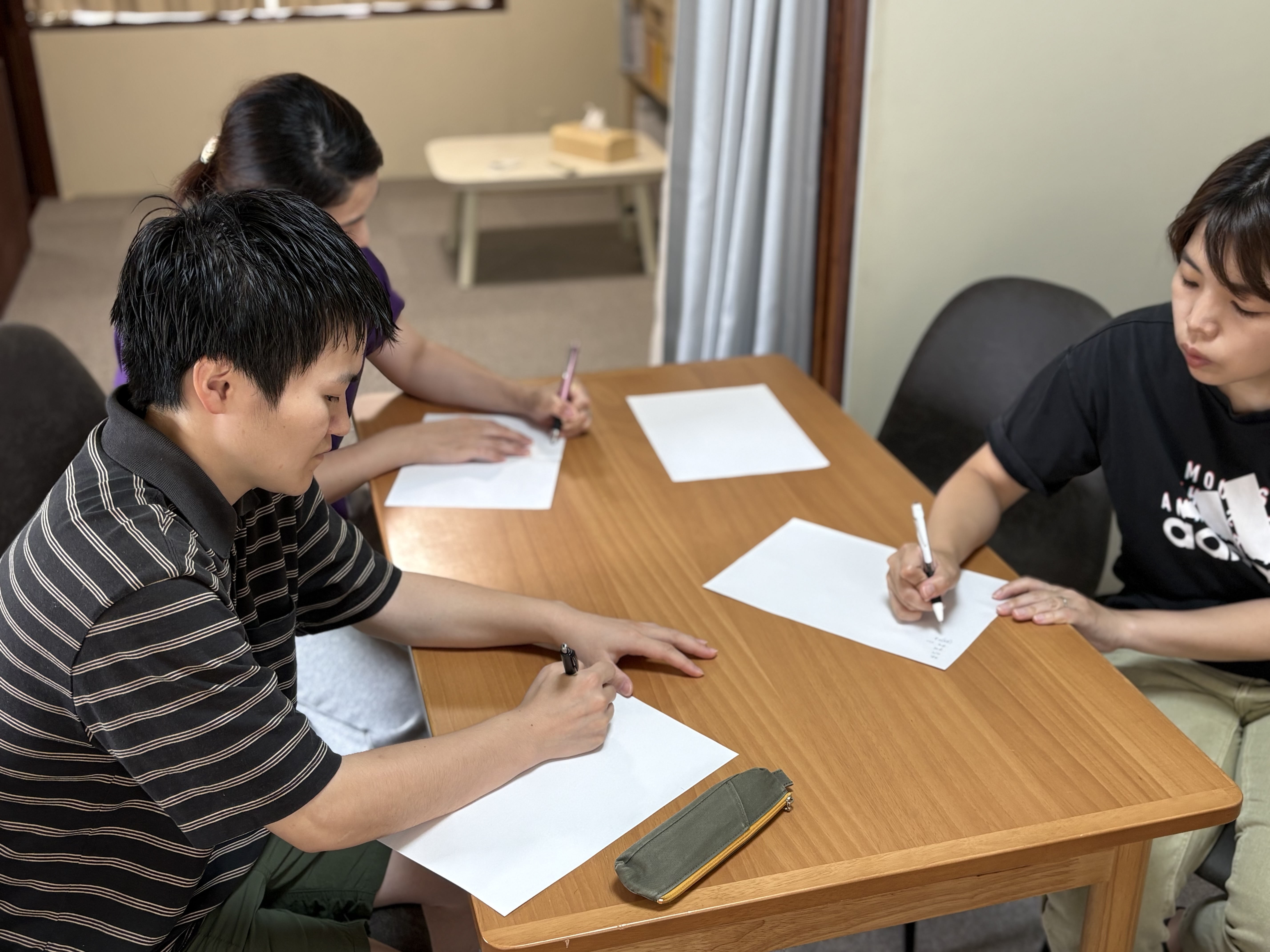 「日々の業務を振り返る。個人情報への意識をノートに書き出すワーク」
「即実践できるチェック体制」を目指し、自分が触れる大切な情報を一人ひとりが真剣にノートに書き出している手元のクローズアップ。