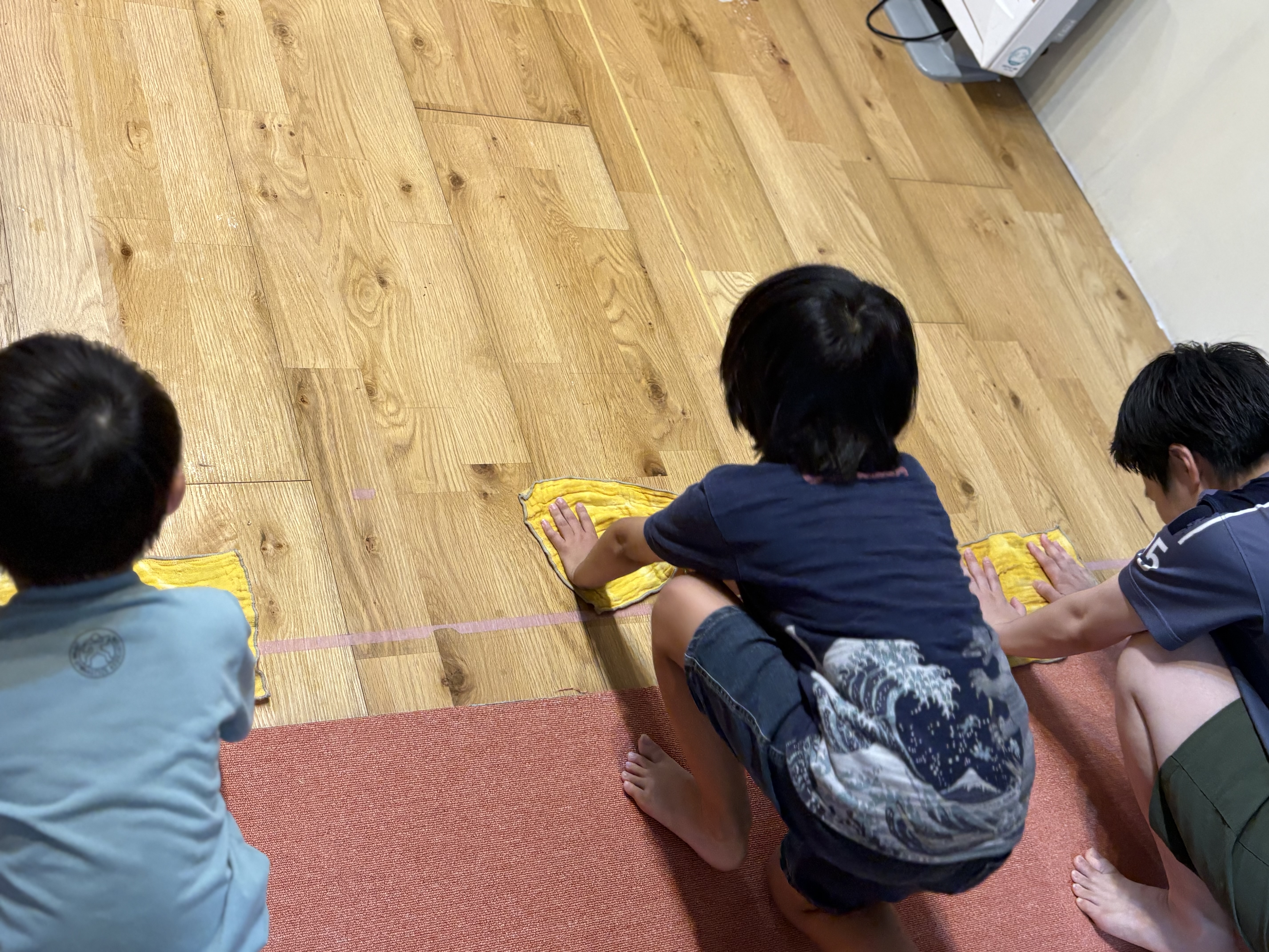 「位置について……!スタートラインで前を見据える真剣な眼差し」
床にぞうきんをセットし、四つん這いの姿勢で「よーい」の合図をじっと待つ子どもたちの引き締まった表情。