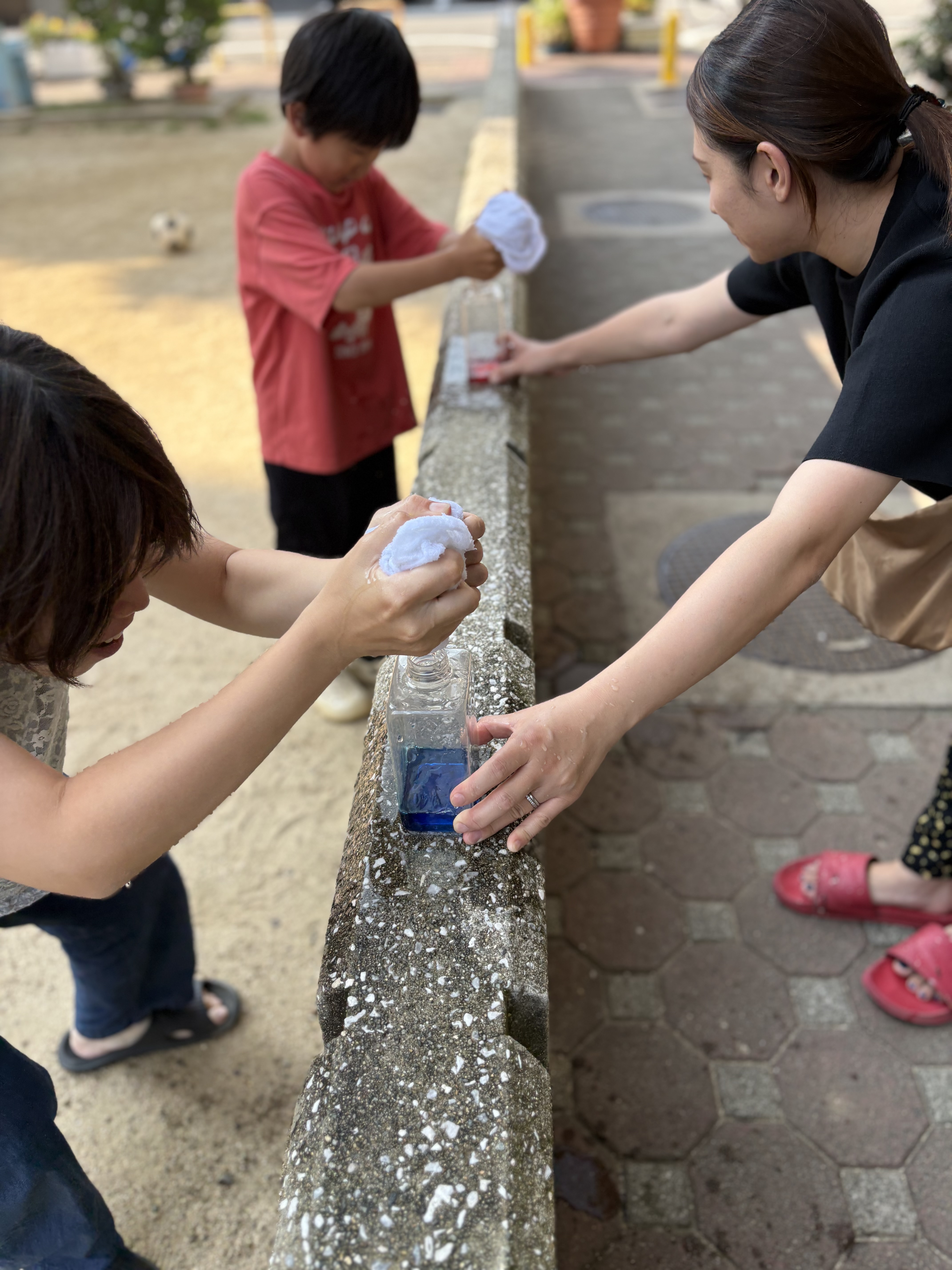 「少しずつ溜まっていく達成感！満タンを目指してラストスパート」
チームのお友達が絞ったお水が蓄積され、ボトルの半分以上まで色水が上がってきた達成感あふれるボトルのクローズアップ。