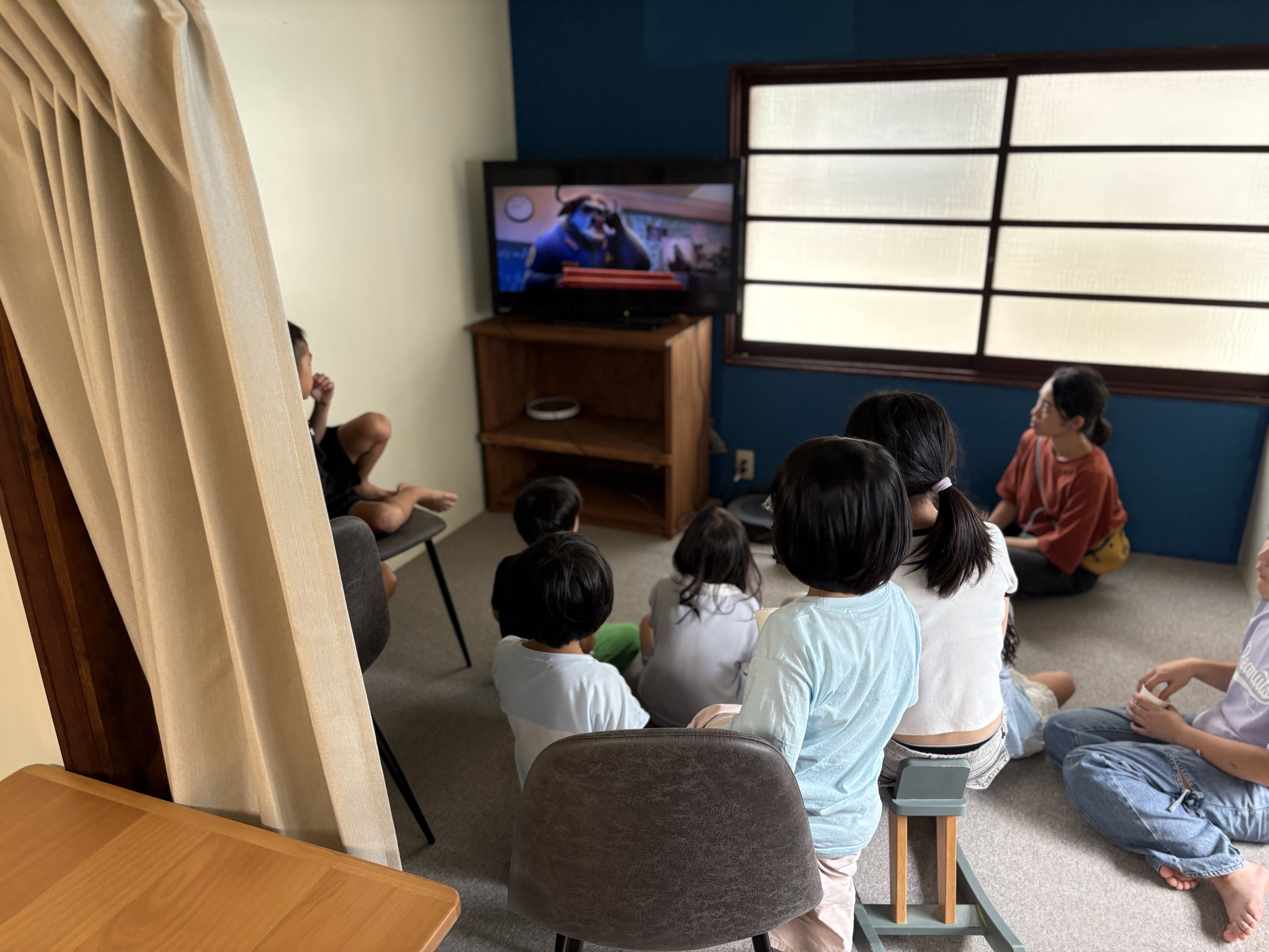 「『あはは！面白〜い！』みんなで顔を見合わせてくすっと笑顔」
映画の面白いシーンで、隣のお友達やスタッフと顔を見合わせて一緒に笑い合う温かい場面。