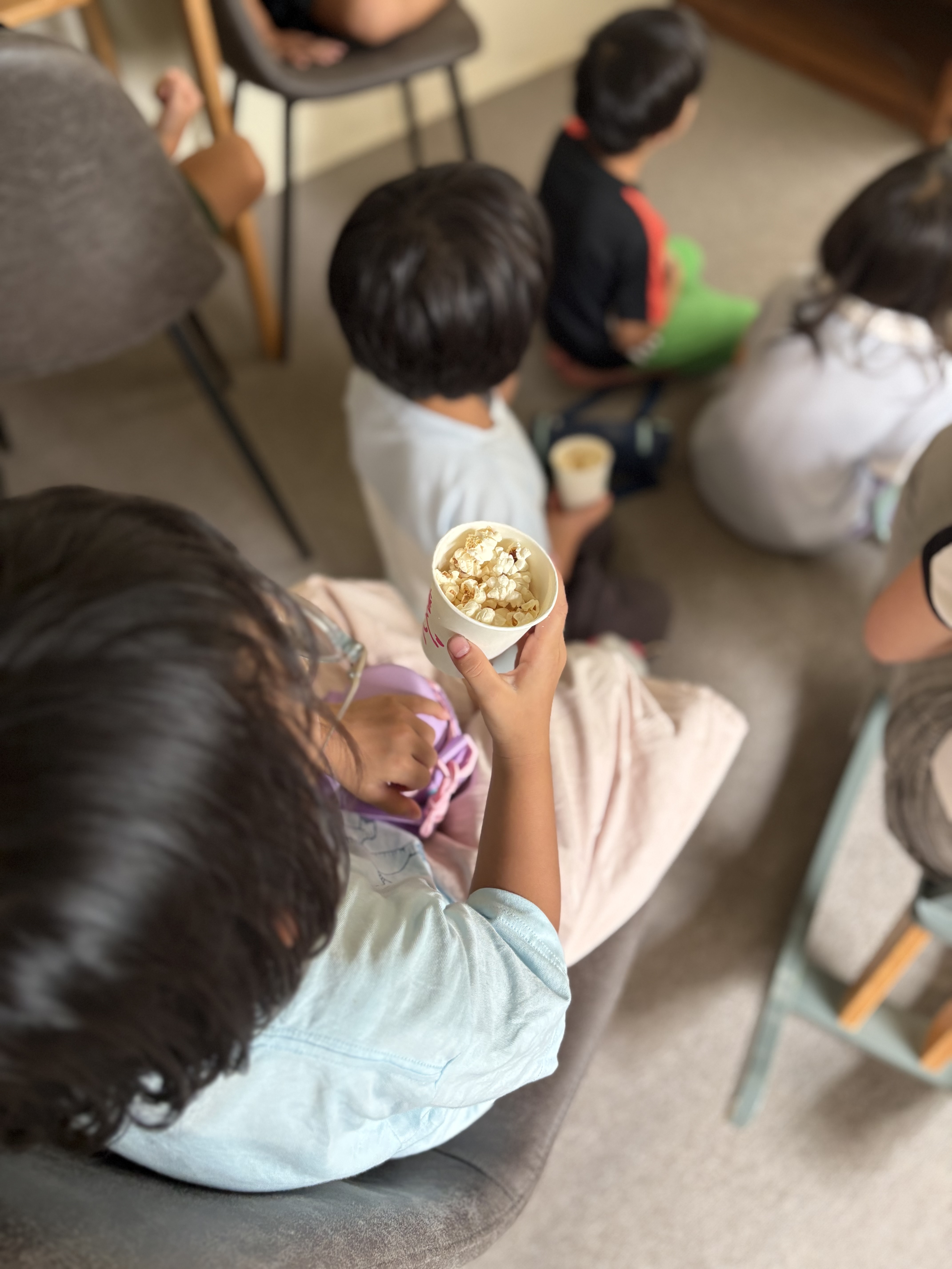 「映画を見ながらパクッ！できたてポップコーンは格別の味」
画面から目を離さずに、自分たちで作ったポップコーンを口へ運んでもぐもぐ味わう至福のカット。