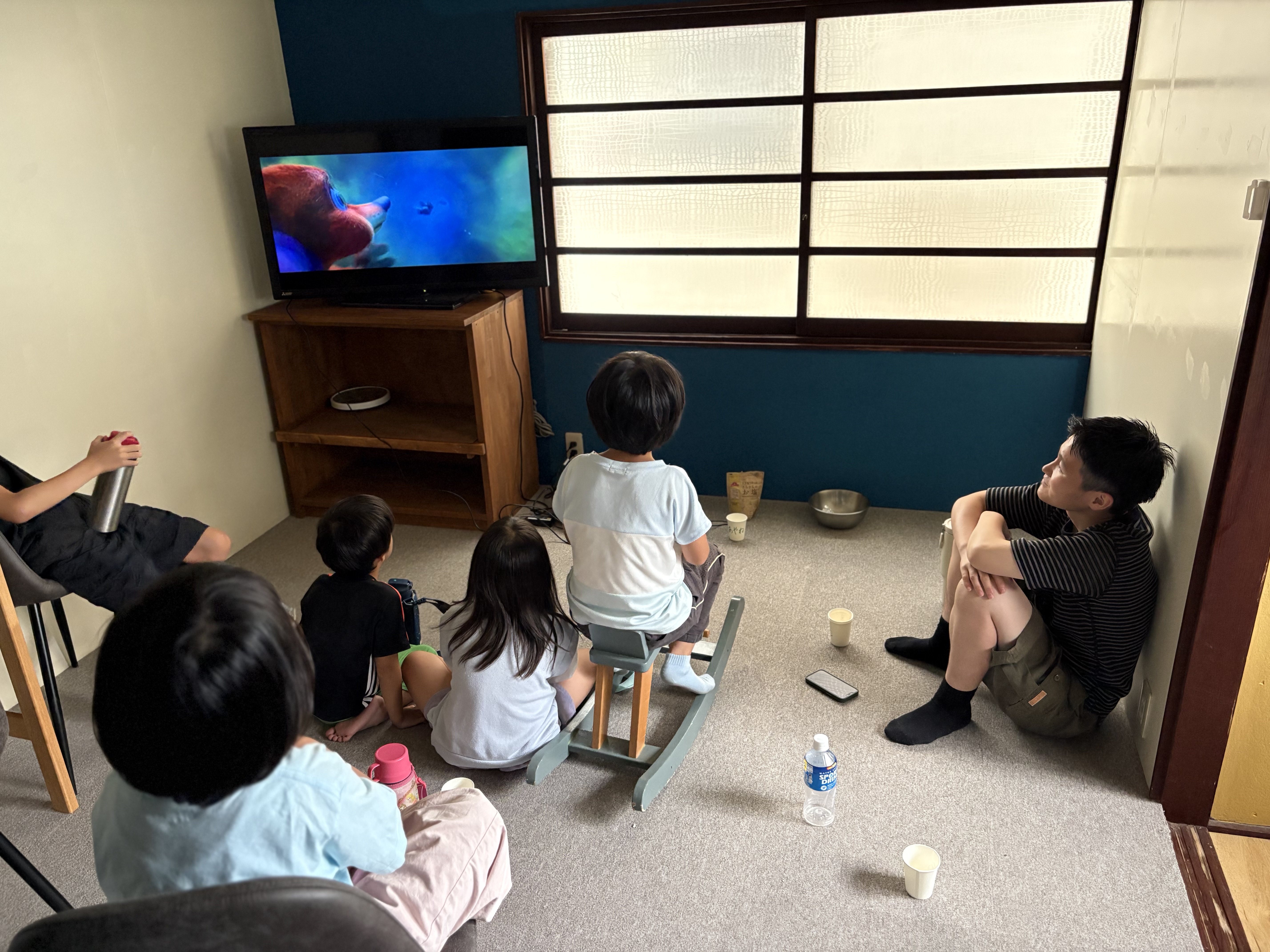 「お部屋の電気をぽちっ。『スレタン映画館』へようこそ！」
カーテンをしめて電気を少し落とし、映画館のような雰囲気に変わったお部屋に集まる様子の引きショット。
