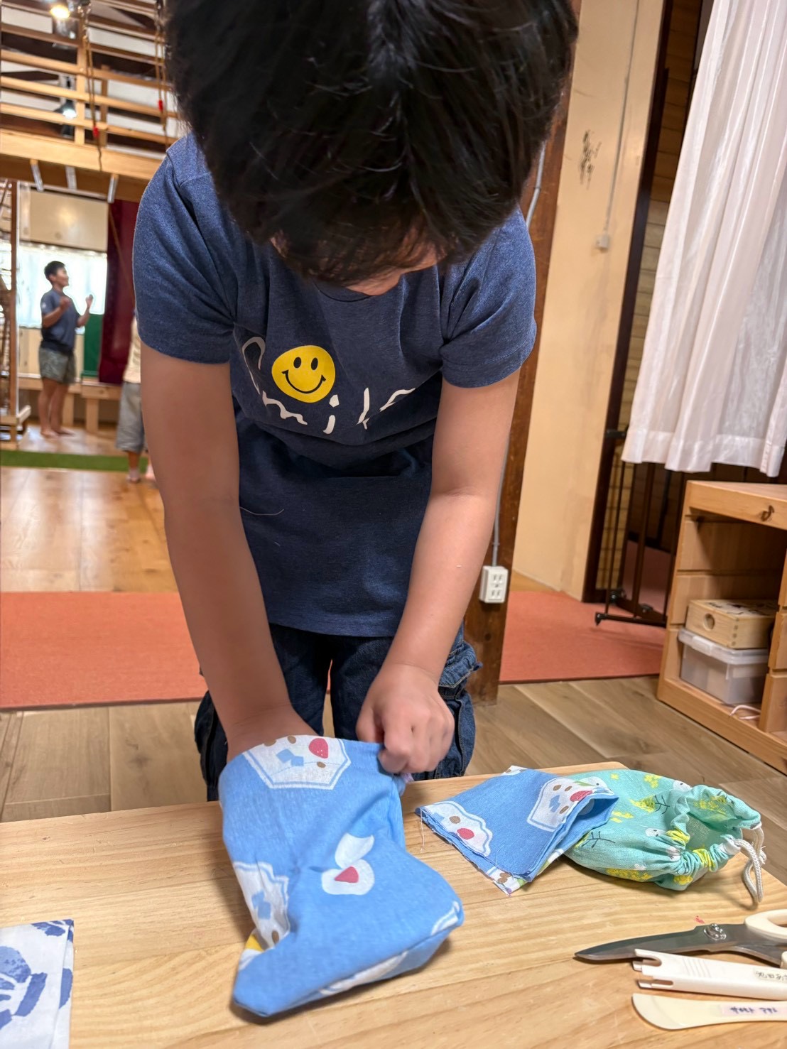 「『給食の時間が楽しみ!』マイ・ランチョンマットでお弁当ポーズ」
さっそく出来上がったマットの上に器を置き、「ここで食べる!」と嬉しそうなカット。