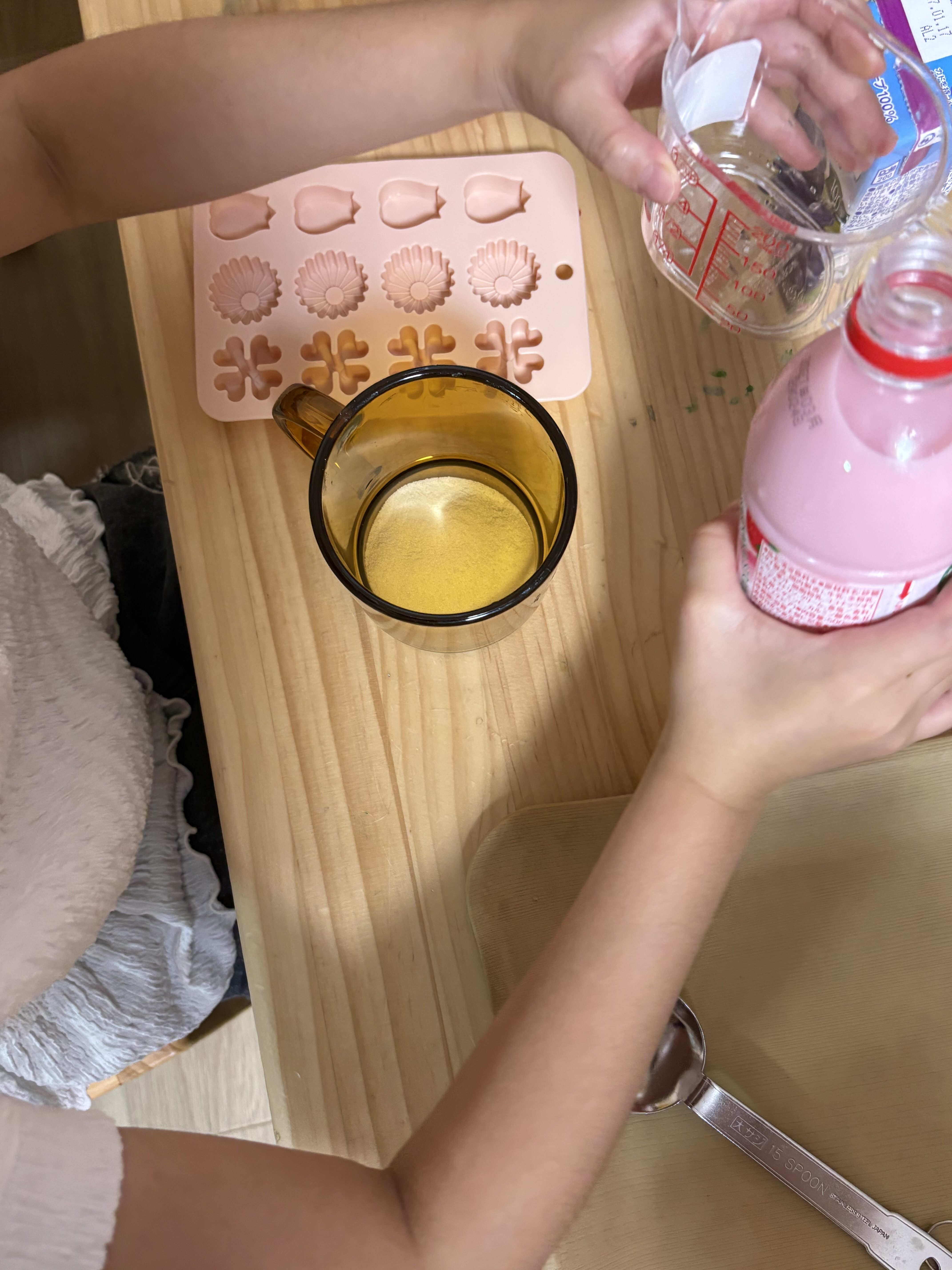 「『美味しそうな匂い…飲みたい！』思わず鼻を近づける葛藤の瞬間」
計量カップに注いだジュースの甘い香りに、「う〜ん、美味しそう！」と一瞬グラッとくる可愛らしい表情。