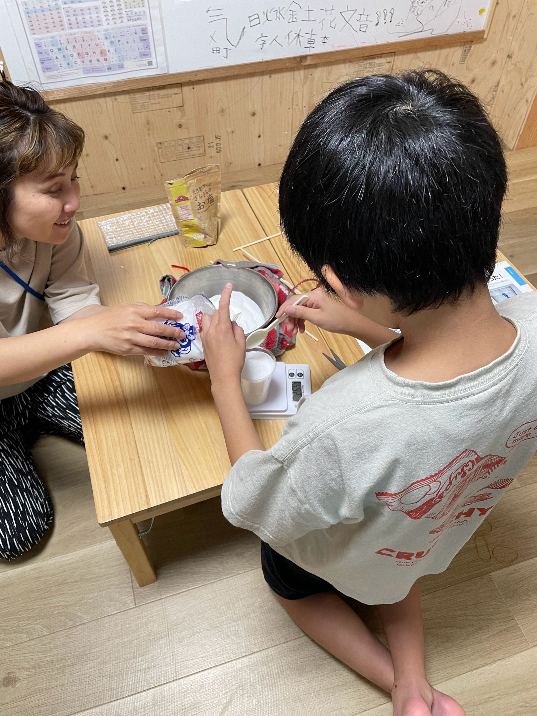 「『科学って面白い！』自分の手で確かめた達成感の笑顔」
実験成功のグラスを前に、実験本を開きながら「大成功！」と満足そうな笑顔を見せる締めの一枚。