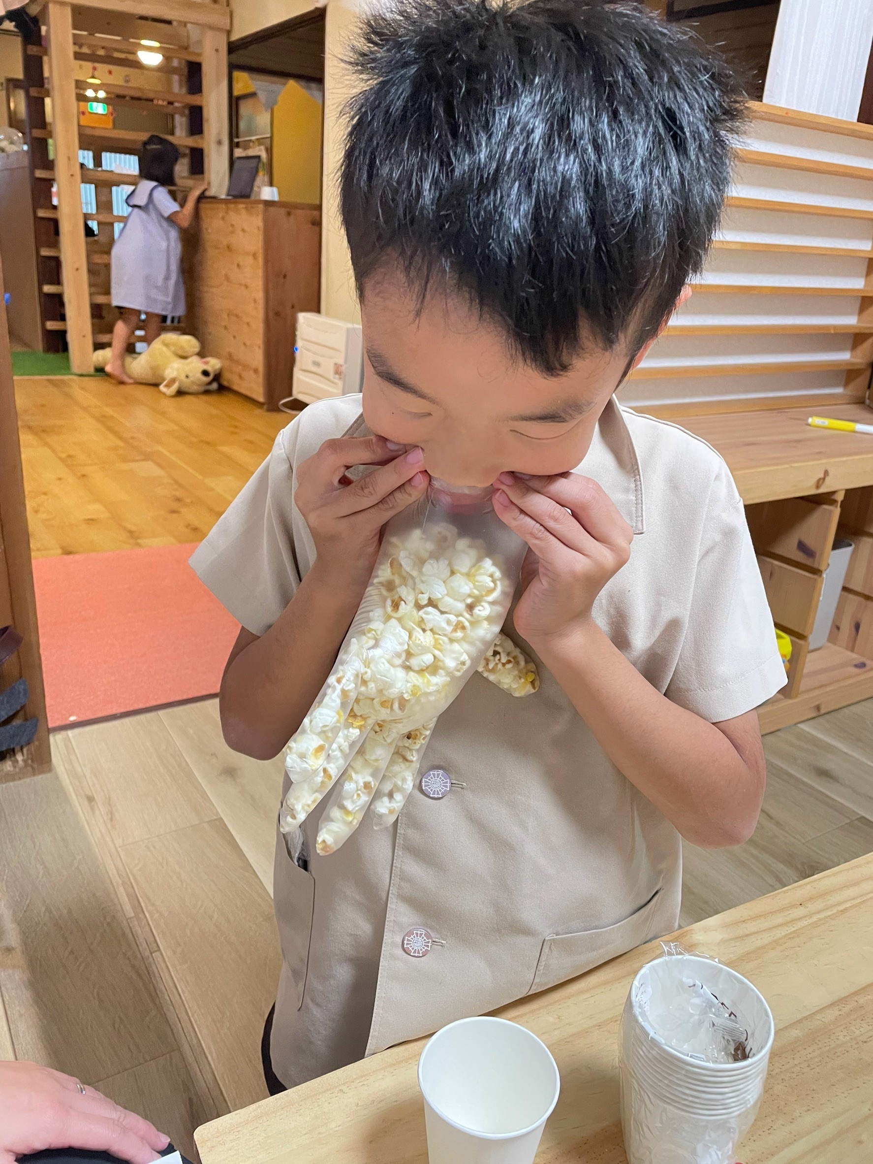 空気を入れて、ポップコーンを入れやすい様に工夫する男の子。