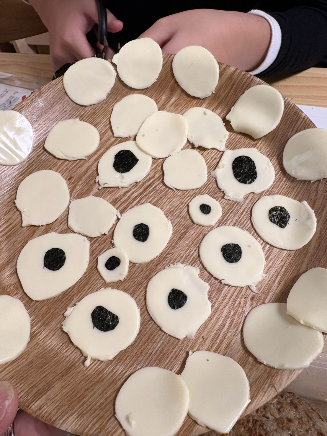 「『チーズの目玉に黒目をペタッ!』命が吹き込まれる瞬間」
くり抜いたチーズの上に、海苔の黒目をピンセットや指先でそーっと乗せて表情を作っている表情。