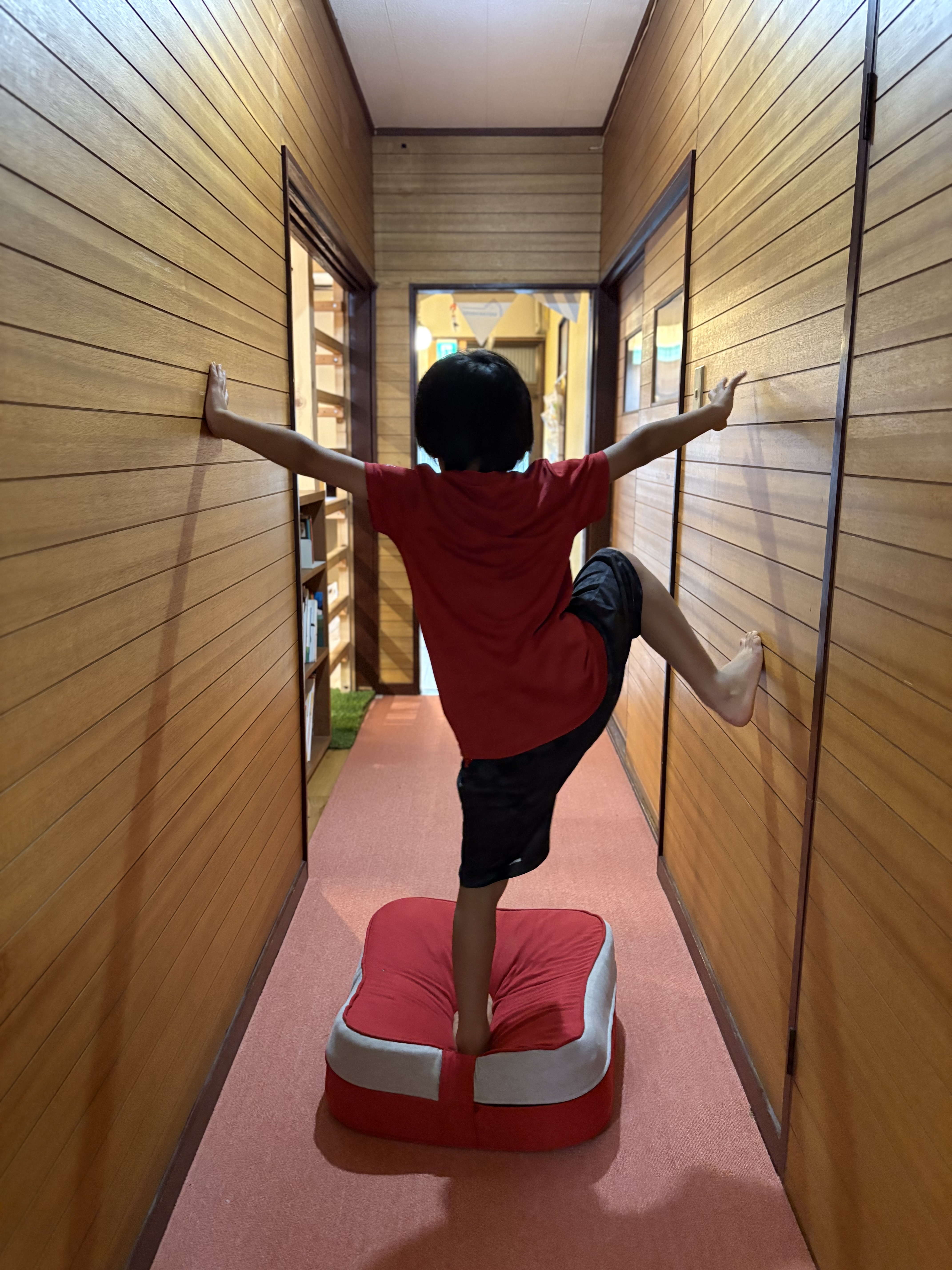 「『えっ、すごっ！僕もやりたい！』刺激を受けて集まる子どもたち」
「すごい！」と目を輝かせ、「自分もできるかな？」と壁に近づく周囲の子どもたちのワクワクした表情。