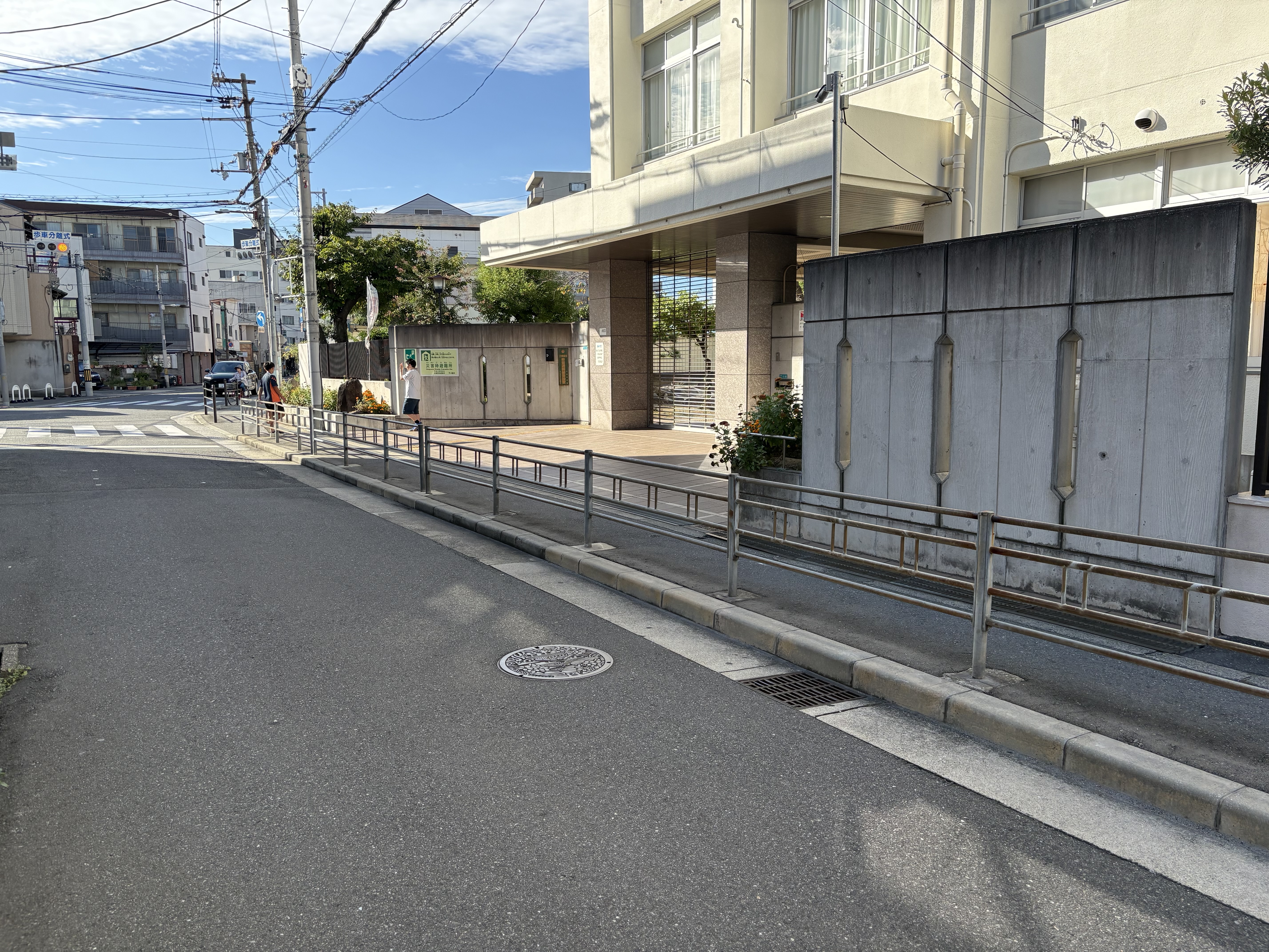 「『この電柱やブロック塀、グラグラしたら危ないね』危険マップを頭に刻む」
通学路沿いのブロック塀や電柱を指差し、「倒れてきたらどう逃げる？」と確認し合う様子。