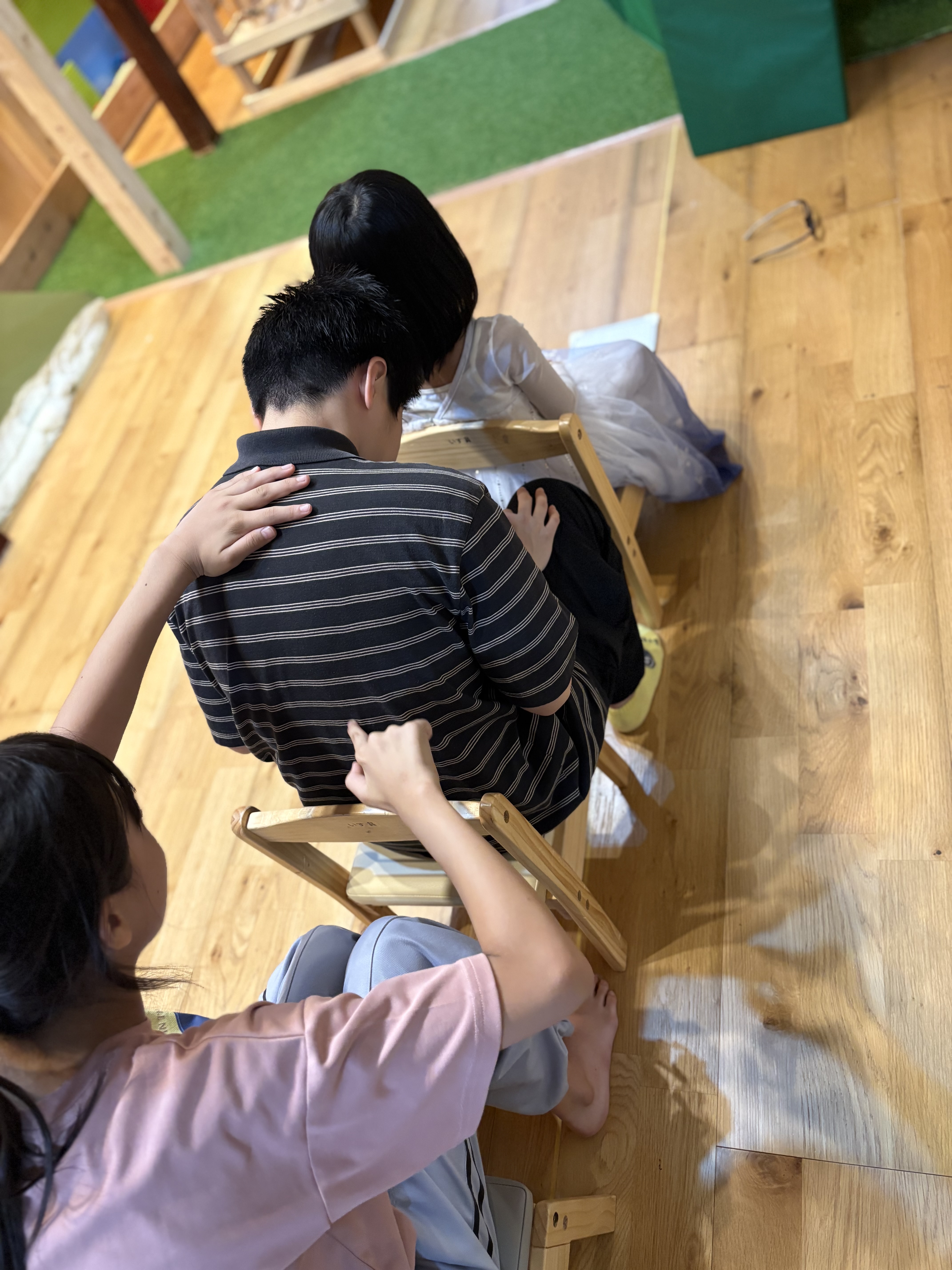 「『くすぐったい…!でも集中、集中!』背中の感覚に研ぎ澄ます表情」
背中を丸めながら「んん…!?」と目をつむり、指先の動き(丸?数字の3?)を一生懸命読み取ろうとする全集中モードの表情。