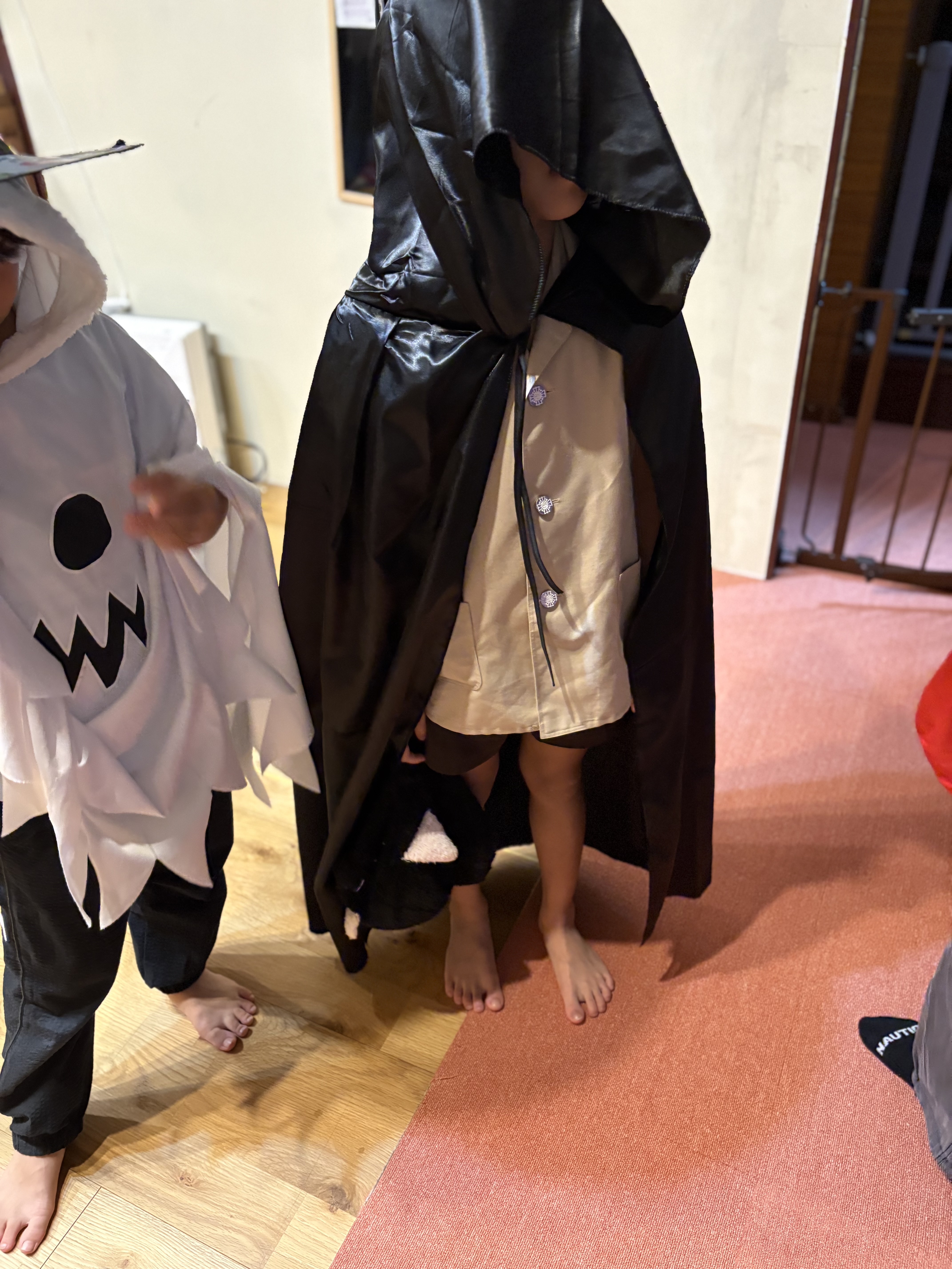 「『ミステリアスな魔法使いになりきり！』黒マントを羽織ったキメ顔」
フード付きの黒いマントを深く被り、呪文を唱えるようなポーズでカッコよく決めポーズをとる一コマ。
