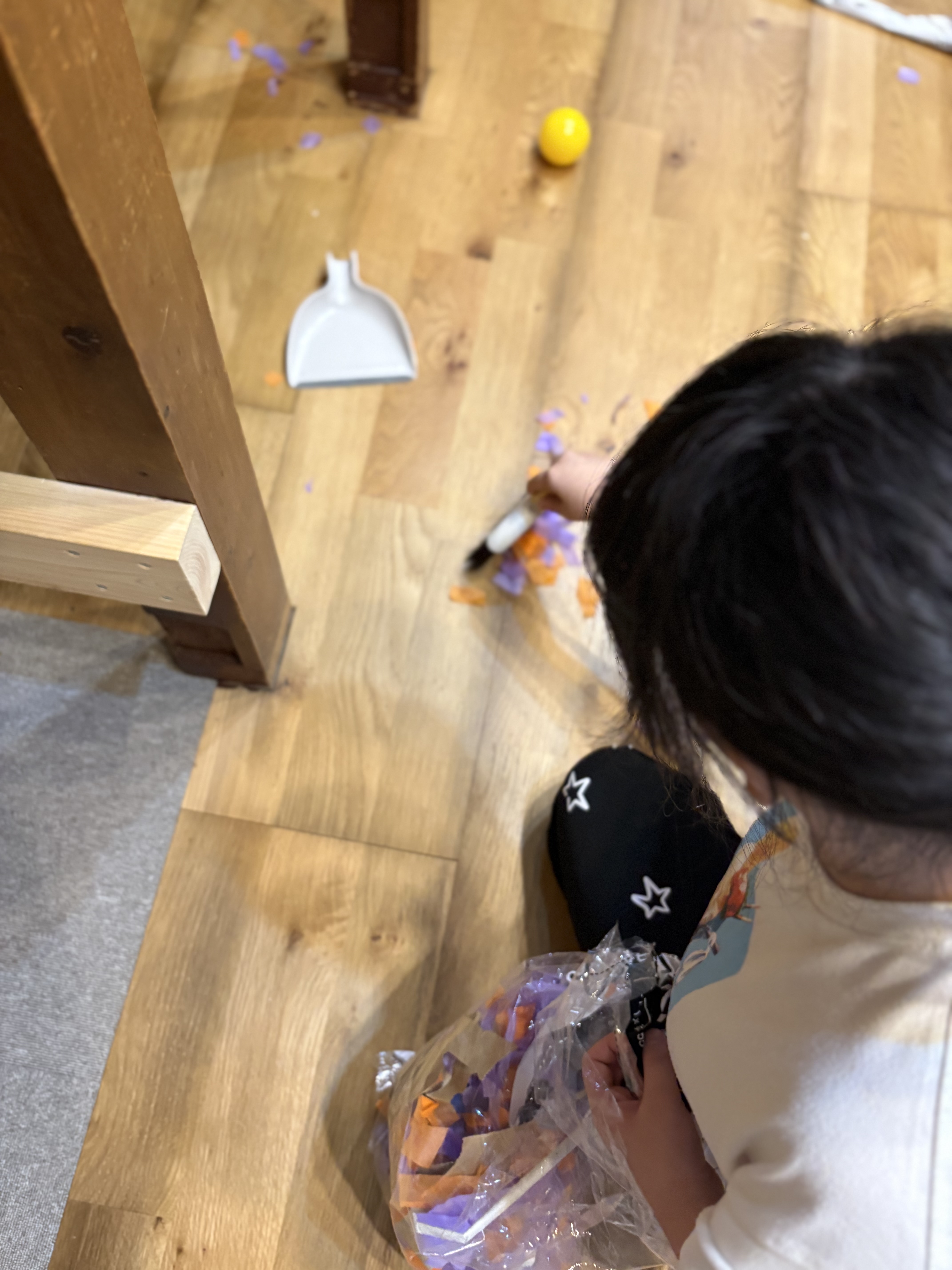 「『ガムテープの輪っかでペタペタ!』「『ほうきとちりとりチームも大活躍!』協力し合ってお部屋をピカピカに」
ほうきで紙吹雪を集める子と、ちりとりを構えて受ける子が「こっち集めてー!」と息を合わせてお掃除する頼もしい姿。